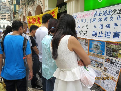 Chinese tourists read about Falun Gong.