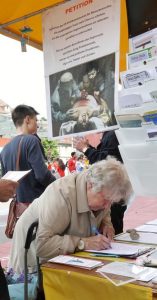 Passersby at the train station in Bern sign a petition condemning the persecution of Falun Gong.
