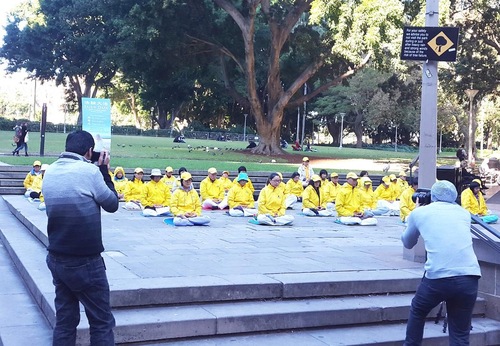 Mr. Samir Abud (right) takes pictures of Falun Gong exercises.