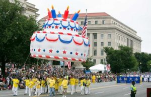 Falun Gong practitioners carry a large birthday cake balloon in the parade