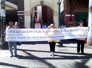 Falun Gong practitioners in Honolulu hold a large banner in Chinatown.