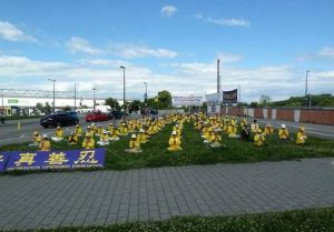 European Falun Gong practitioners holding group exercises on the grass near the parliament building.