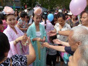 People are happy to receive small folded paper lotus flowers with a bookmark printed with “Falun Dafa is good.”