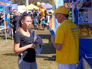 Passerby taking brochures at the Falun Dafa stall.