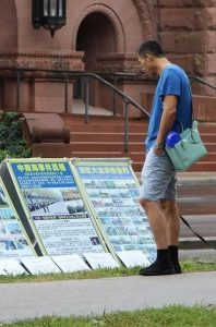 A passersby reads display boards introducing Falun Gong and raising awareness about the 17-year persecution of the practice in China.