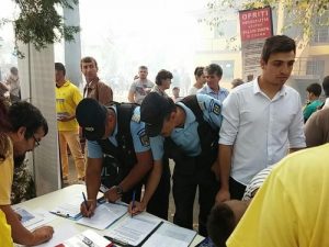 Two military police officers sign petitions.