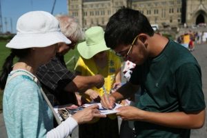 Canadian citizens sign the petition in front Parliament Hill to condemn the persecution of Falun Gong.