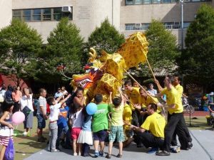 Delighted children touch the dragon's head for good luck.