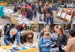 Many pedestrians signed petitions to support Falun Dafa practitioners.