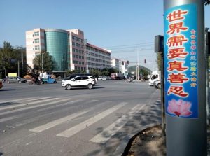 The poster reads “The World Needs Truthfulness-Compassion-Forbearance.”