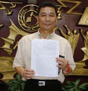 Council member Cheng Chin-long, sponsor of the resolution, holds the document.