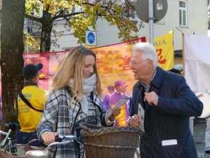 A passerby paused to accept a flyer from a Falun Gong practitioner.