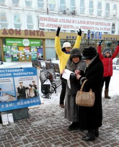 Two practitioners demonstrate the Falun Gong exercises while a passerby signs a petition in the City of Irkutsk, Siberia, Russia.