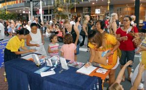 Passerbys stopped to sign a petition to support stopping the brutal persecution of Falun Gong in China.