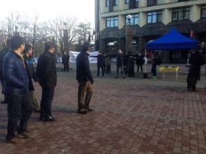 Chinese tourists pause to look at the large Falun Gong banner.