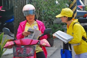 Distributing newspapers with Falun Gong information to passersby.