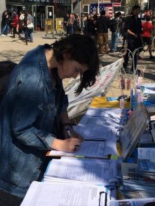 One young woman signs a petition.