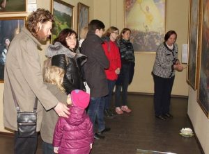 Visitors view the artworks and learn the stories behind the paintings.