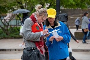 Passerby signs a petition to help practitioners in Vancover, Canada.