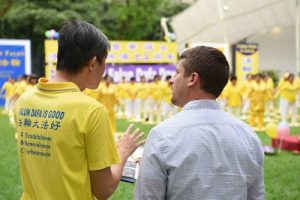 A passerby learns about Falun Gong at the World Falun Dafa Day celebration in Hong Lim Park on May 2, Singapore.