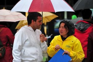 A practitioner explains the suppression in China to a passerby.