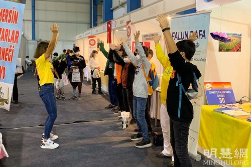 Book fair attendees came to the Falun Dafa booth to learn the exercises.