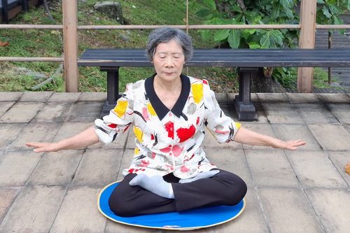 Yue’e practicing the fifth Falun Dafa exercise, the meditation.

