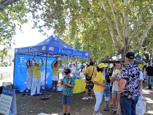 Falun Dafa practitioners introduce the practice and demonstrate the exercises at their stall. Visitors learned about the 25-year-long persecution of the practice in China.

