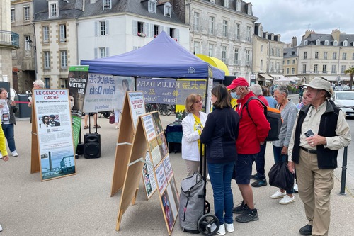 Practitioners set up an information booth to introduce Falun Dafa at Place Gambetta opposite the Vannes port on May 24, 2025.

