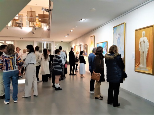 People viewed the paintings displayed in the exhibition at the opening night.


